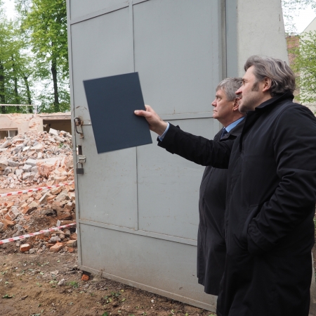 Two people at the construction site, one of them pointing into the distance