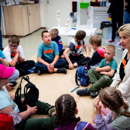 Children and an adult sitting in a circle on the floor