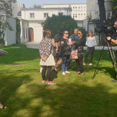 Several people standing in the garden, speaking to the camera