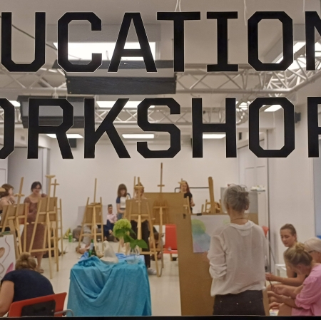 kilkanaście osób w sali warsztatowej stojących przy sztalugach