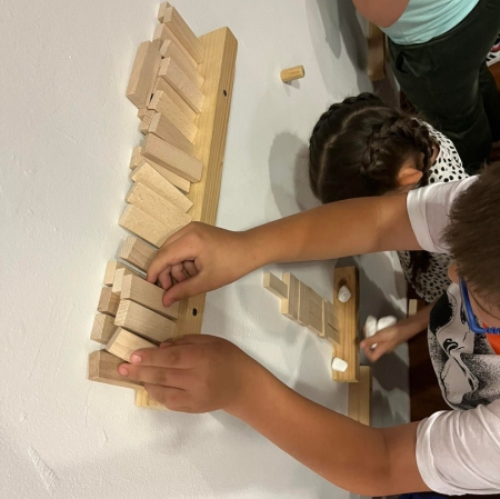 Hands arranging wooden blocks on the floor