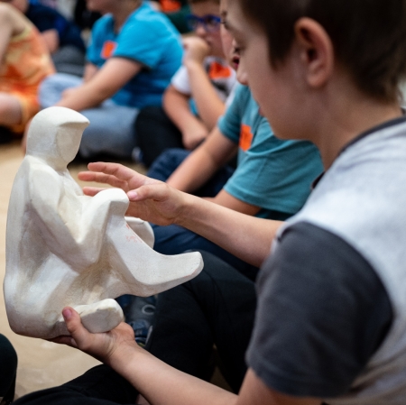 A person holding sculpture in hands