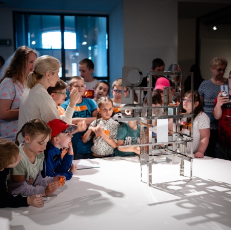 People in the exhibition space standing around the sculpture