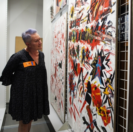 A person looking at works of art in a warehouse