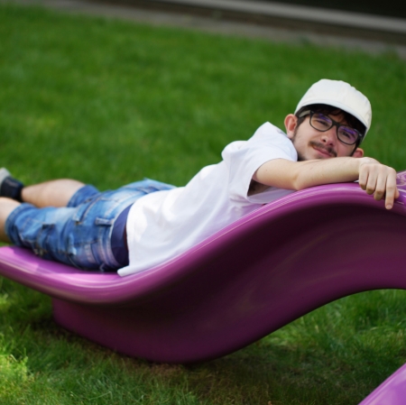 Person lying on a purple bench with an abstract shape