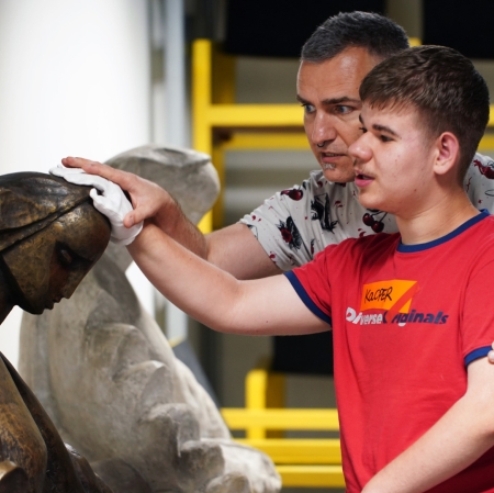 a blind person touching a sculpture