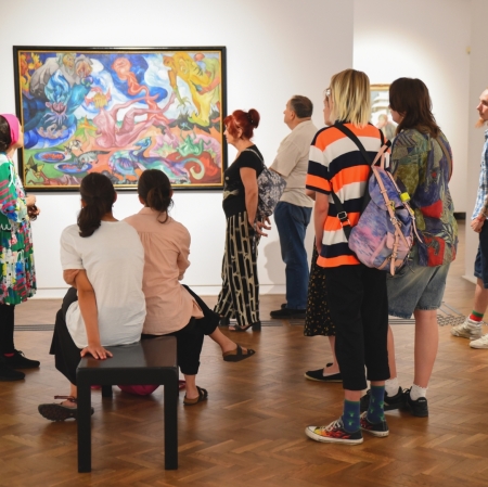 a group of people taking a tour of the Neoplastic Room exhibition space. Initial state