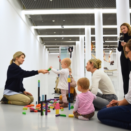 women and children in the exhibition space stacking wooden blocks