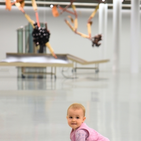 A little girl crawling in the exhibition space