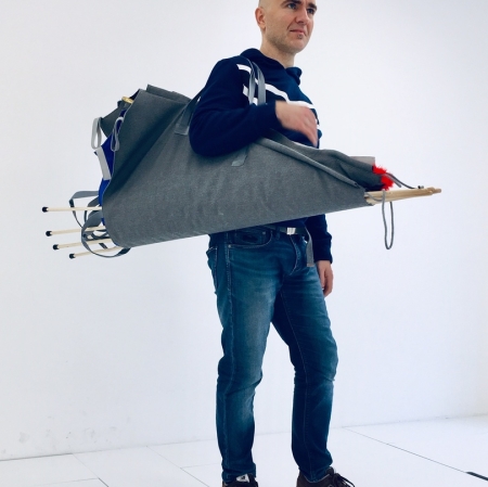 A person standing with an item hanging on his shoulder