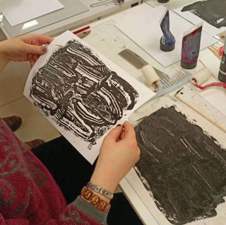 hands holding a linocut they had prepared