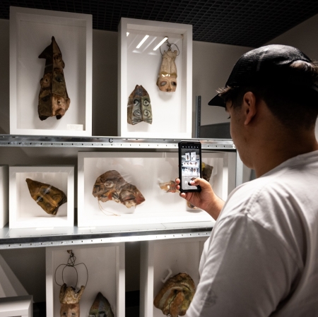 A person looking at works of art in a warehouse