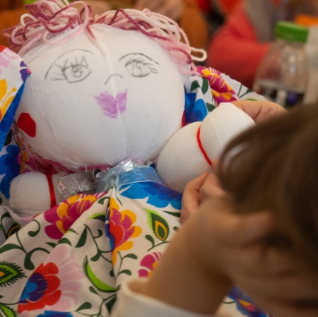 Close-up of a handmade doll in a colorful dress.
