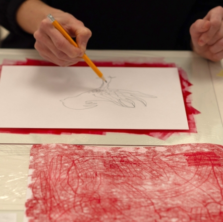 hands of person sketching with yellow pencil