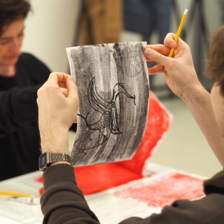 mężczyzna trzymający kartkę z przygotowaną przez siebie grafiką