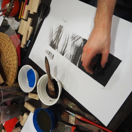 a person paints while holding a ball-like object in his hand