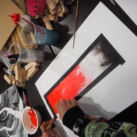 a person paints on a designated area on a piece of paper; gradient image