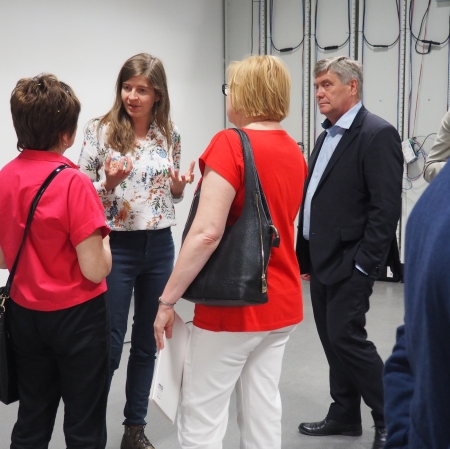 People standing in front of microphones, other people around