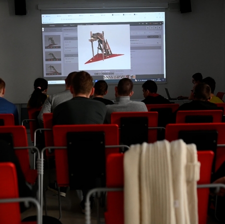 People sitting in an educational room, an image from a projector can be seen on the wall