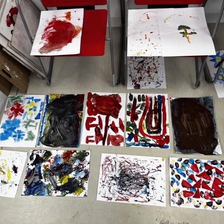 collection of various painting works arranged on the floor, top view
