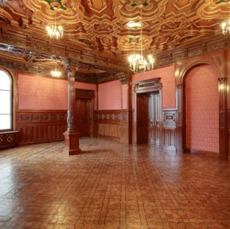 The palace interior is decorated in dark colors, the ceiling and floor are covered with dark wood
