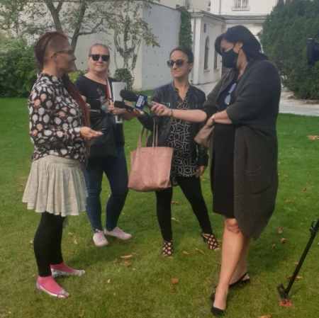 Several people standing in the garden, speaking to the camera