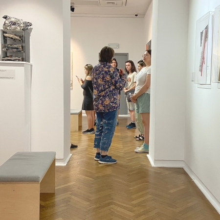 kilka osób w przestrzeni wystawy, widocznych z oddali