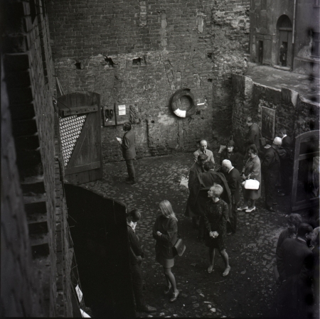 Andrzej Różycki, Otwarcie Wystawy Fotografii Grupy Zero-61, Stara Kuźnia, ulica Podmurna 32, Toruń, 10 maja 1969 - na drzwiach fragment pracy Wojciecha Bruszewskiego Układ fotograficzny (1969);  na ścianie assemblage Józefa Robakowskiego Po człowieku (1969) i Chora opona (1969); na ścianie po prawej praca Michała Kokota Dziewczynka [?] (ok. 1969), skan z negatywu, kolekcja Andrzeja Różyckiego/CSW w Toruniu