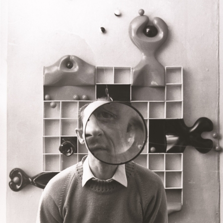 Czarno białe zdjecie Stefana Krygiera na tle dzieła abstakcyjnej formy. Zdjęcie dzięki uprzejmości prof. Moniki Krygier