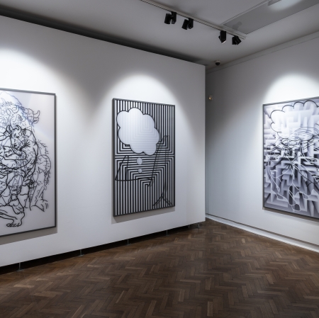 three paintings hanging on the wall in the exhibition space