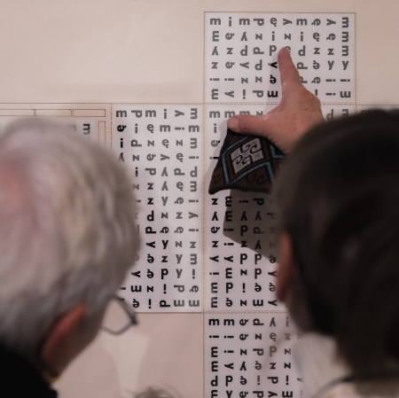 zbliżenie na dwie osoby przyglądające się grafice. Jedna z nich wskazuje na coś palcem.