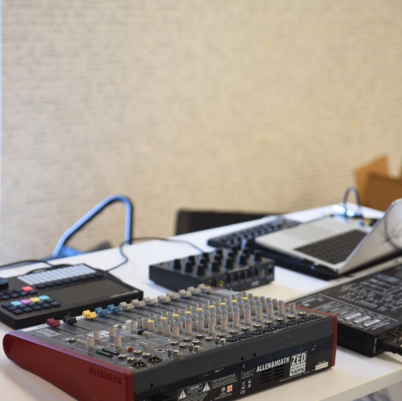 Widok z góry na stół z ustawioną na nim konsolą. W tle ściany wypełnione kośćmi.