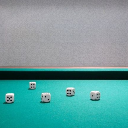 Zbliżenie na stół do gry, na którym leżą kości.