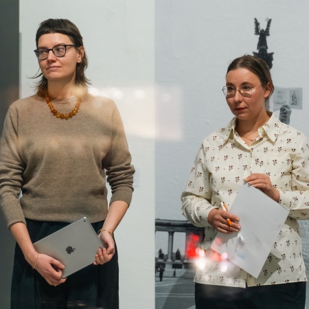 dwie kobiety stoją obok siebie. obie patrzą w jednym kierunku.