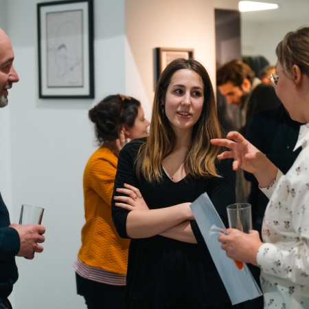 kilka osób w przestrzeni wystawy, rozmawiają.