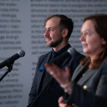 Two people standing at microphones