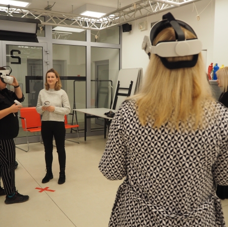 Osoby korzystające z googli vr spacerują w przestrzeni sali edukacyjnej