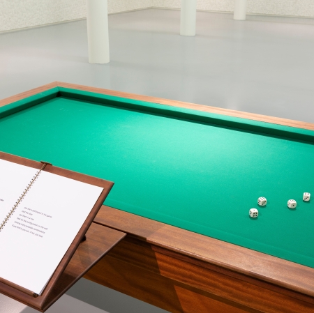 Widok z góry na stół, na którym leżą rozrzucone kości. Po lewo widać instrukcję dotyczącą gry.